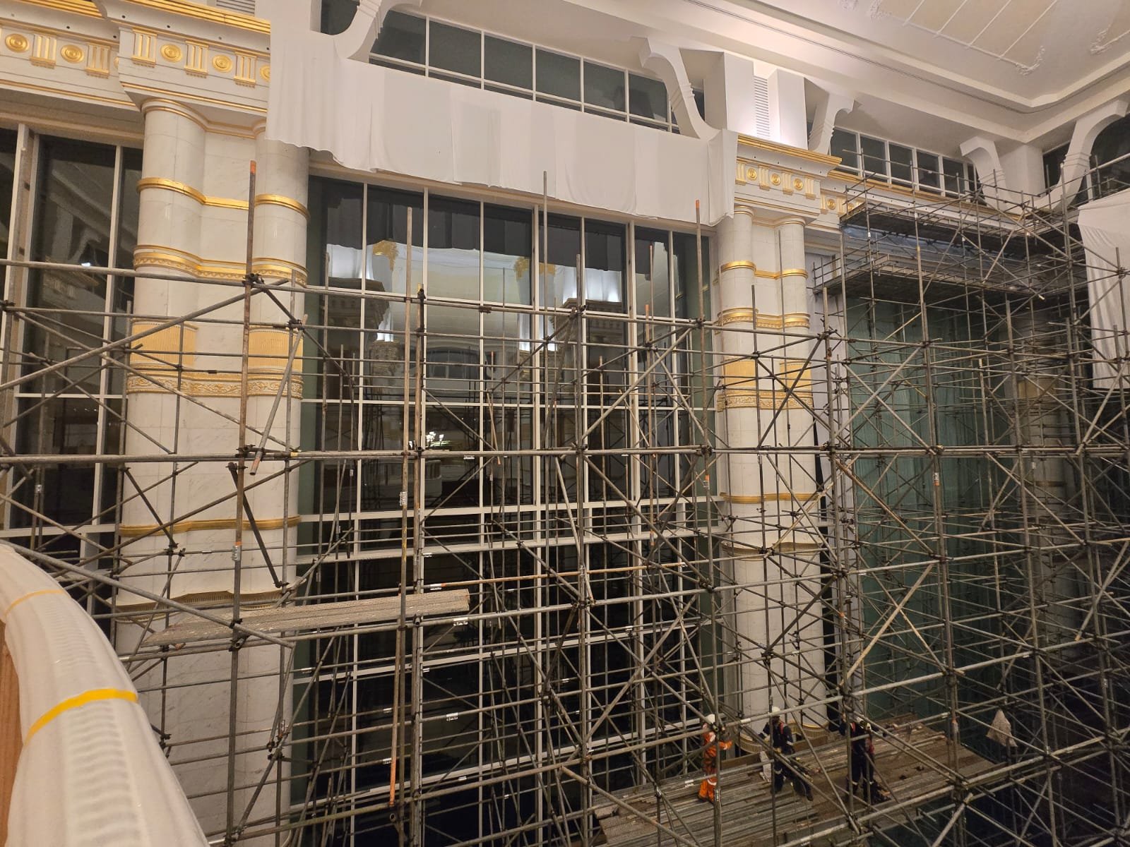 Full-height scaffold installation inside a marble and gold atrium