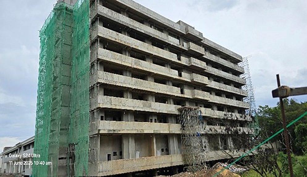Mid-rise building under construction with green safety netting