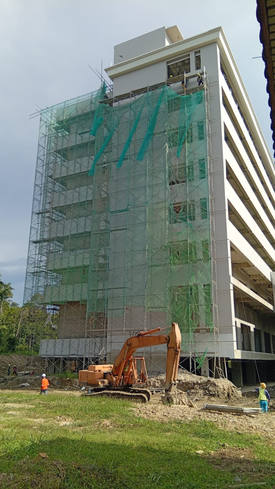 High-rise building fully wrapped in scaffolding and safety netting