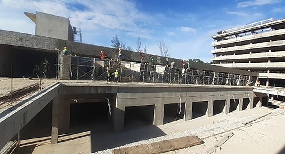 Wide rooftop construction shot with high-rise in background